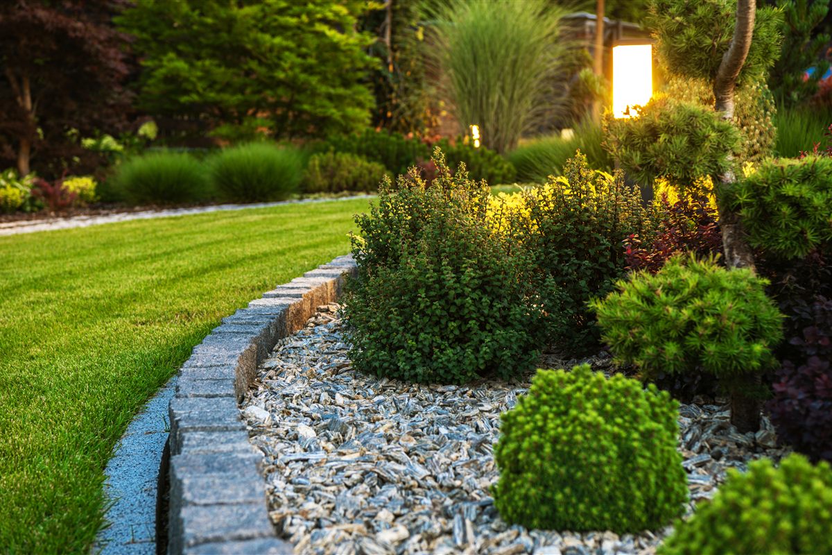 garden-bed-landscape-rock Professionally landscaped garden bed with lawn, rock edging and outdoor lighting